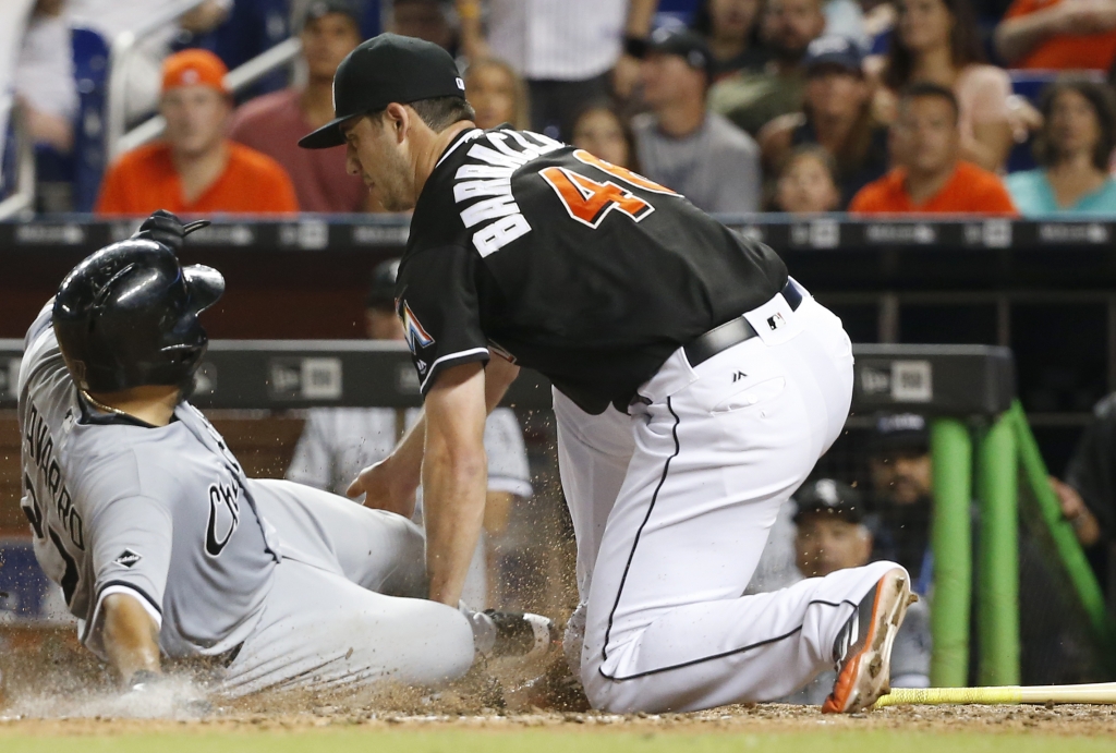 Chicago White Sox's Dioner Navarro slides into home for the go-ahead run as Miami Marlins relief pitcher Kyle Barraclough is unable to hang onto the ball during the eighth inning of a baseball game Saturday Aug. 13 2016 in Miami. (AP