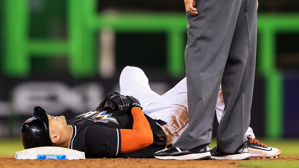 Giancarlo Stanton lies injured on the field after the last play of the game against the Chicago White Sox at Marlins Park