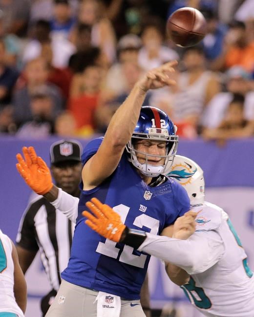 New York Giants quarterback Ryan Nassib is hit by Miami Dolphins defensive end Chris Mc Cain during the first quarter of an NFL football game Friday Aug. 12 2016 in East Rutherford N.J