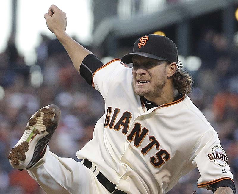 Giants&#039 Jake Peavy follows through on a pitch against the Cincinnati Reds during the third inning of a baseball game in San Francisco Monday