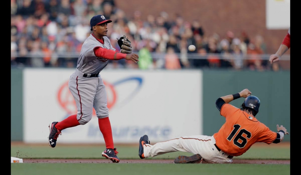 Washington Nationals shortstop Wilmer Difo left turns a double play over San Francisco Giants&#039 Angel Pagan after a ground ball was hit by Giants&#039 Joe Panik during the first inning of a baseball game Friday