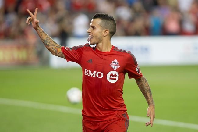 Toronto FC's Sebastian Giovinco celebrates scoring his third goal from the penalty spot to give his team a 3-0 lead over New England Revolution during second half MLS action in Toronto on Saturday