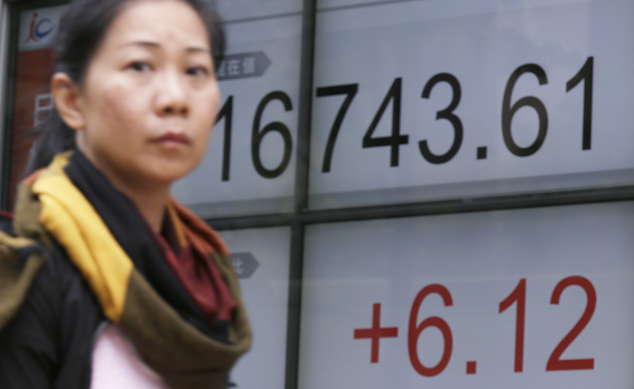 A woman walks past an electronic stock board showing Japan's Nikkei 225 index at a securities firm in Tokyo Tuesday Aug. 30 2016. Asian shares were mostly