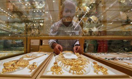 A salesman arranges a gold necklace in a display case inside a jewellery showroom on the occasion of Akshaya Tritiya in Kolkata