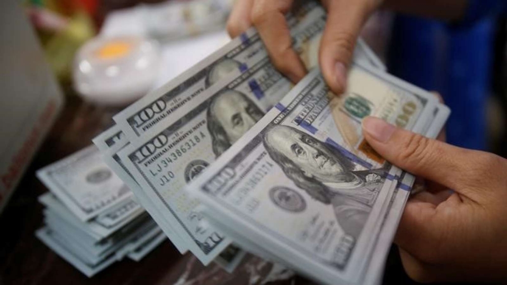 An employee of a bank counts US dollar notes at a branch in Hanoi Vietnam