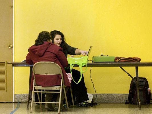 Carolyn Gomez of Covering Kids and Families helps Maria Aguilar Sanchez of Milwaukee sign up for the Affordable Care Act at Centro Hispano High School on Dec. 20 2014