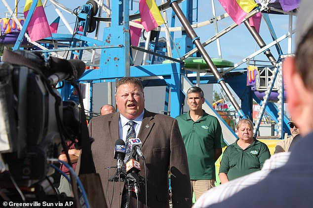 Greeneville Police Detective Capt. Tim Davis answers questions at the foot of the Ferris wheel at the Greene County Fair on Tuesday