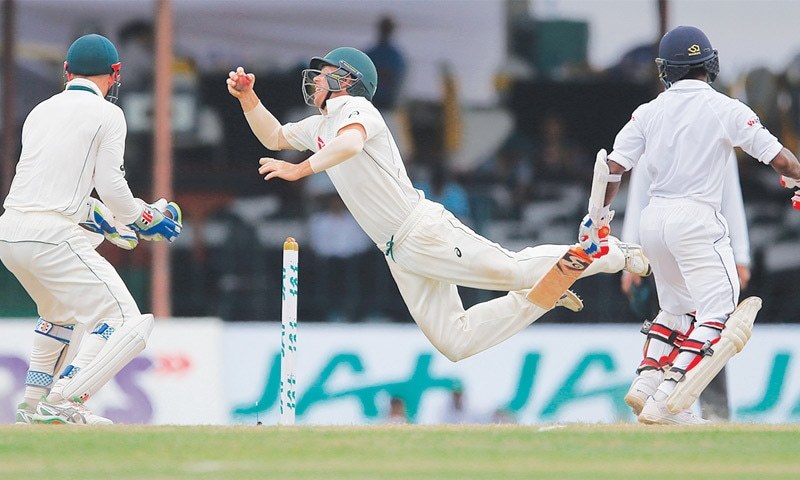 COLOMBO Australia’s close-in fielder David Warner dives to stop the ball as Sri Lankan batsman Kaushal Silva and wicket-keeper Peter Nevill look on during the third Test at the SSC Ground on Tuesday.—AP