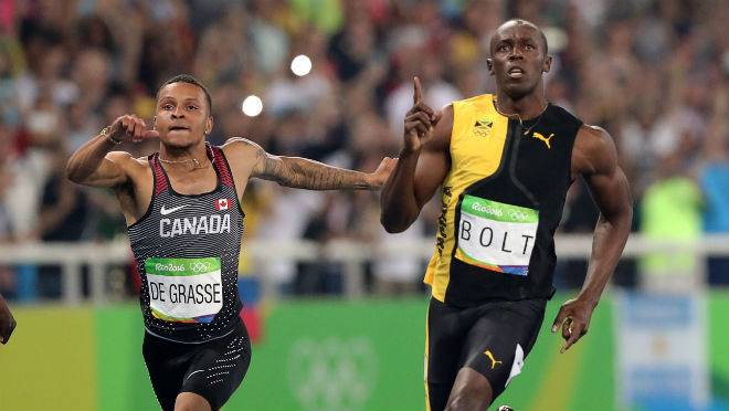 Jamaica's Usain Bolt celebrates as he crosses the line to win gold in the men's 100-meter final with Canada's Andre de Grasse during the athletics competitions of the 2016 Summer Olympics at the Olympic stadium in Rio de Janeiro Brazil Su