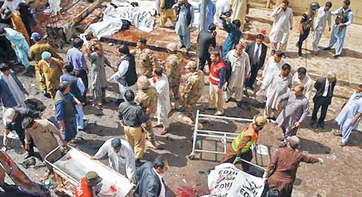 TOPSHOT- Pakistani security officials and lawyers gather around the bodies of victims killed in a bomb explosion at a government hospital premises