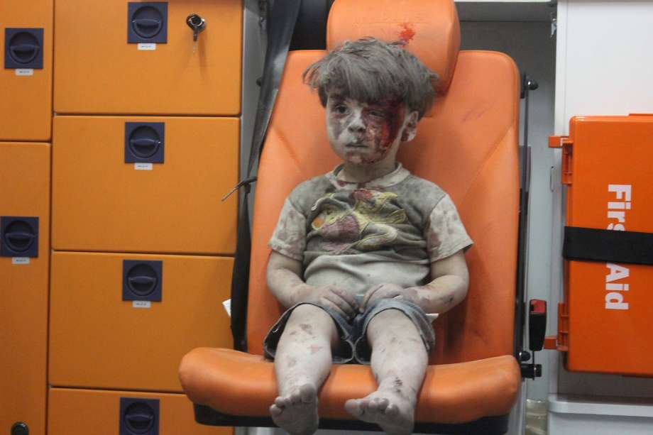 Omran a four-year-old Syrian boy covered in dust and blood sits in an ambulance after being rescued from the rubble of a building hit by an air strike in the rebel-held Qaterji neighbourhood of the northern Syrian city of Aleppo late