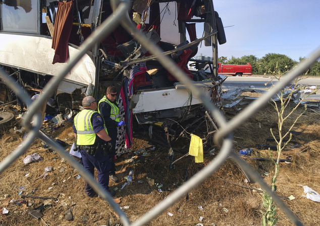 California Highway Patrol officers investigate the scene of a charter bus crash on northbound Highway 99 between Atwater and Livingston Calif. Tuesday Aug