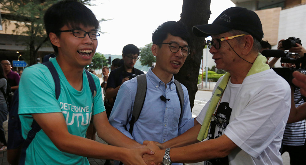 Student leaders Joshua Wong and Nathan Law are greeted by a supporter after a verdict on charges of inciting and participating in an illegal assembly in 2014 which led to the Occupy Central pro-democracy movement outside a court in Hong Kong Aug