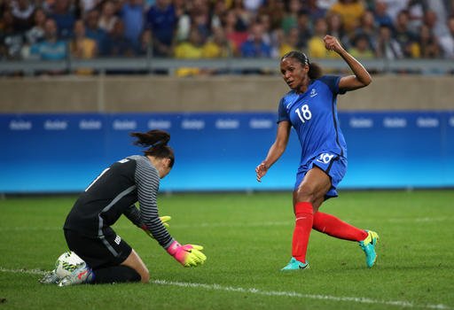 United States goalkeeper Hope Solo left makes a save as France's Maire Laure Delie looks on during a group G match of the women's Olympic football tournament between United States and France at the Mineirao stadium in Belo Horizonte Brazil Saturday