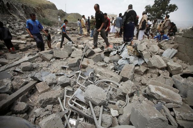 People inspect damage at a house after it was destroyed by a Saudi-led air strike in Yemen's capital Sanaa