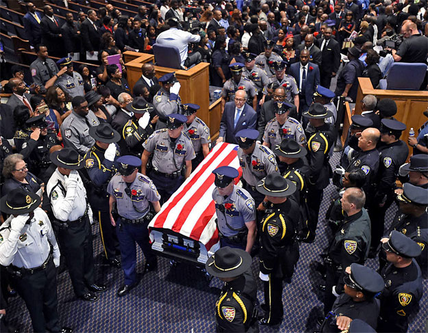 The casket of slain Baton Rouge police Cpl. Montreal Jackson is carried out at the conclusion of his funeral at the Living Faith Christian Center in Baton Rouge LA Monday