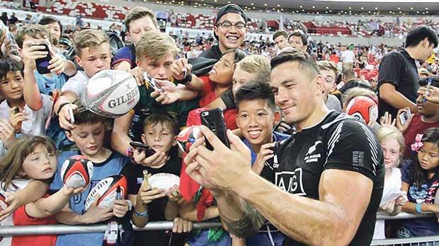 Sonny Bill Williams posing for a selfie with young rugby Sevens fans