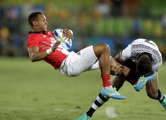 ASSOCIATED PRESS           Britain’s Dan Norton left is tackled by Fiji’s Osea Kolinisau during the men’s rugby sevens gold medal match at the Summer Olympics in Rio de Janeiro Brazil