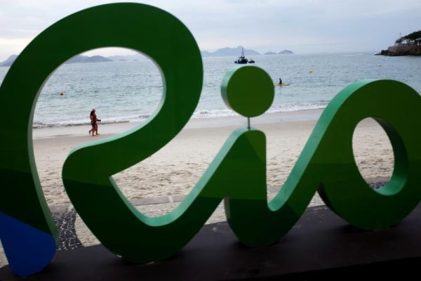 A couple walks along Copacabana beach ahead