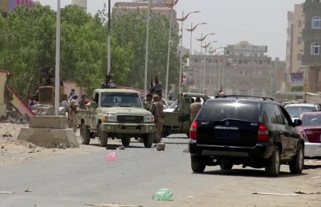 Soldiers gather at the site of an attack by a suicide bomber who drove a car laden with explosives into a compound run by local militias in the southern port city of Aden Yemen