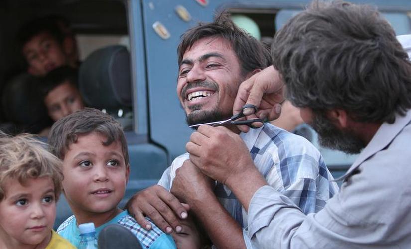 A man cuts the beard of a civilian who was evacuated with others by the Syria Democratic Forces from an IS-controlled neighbourhood in Aleppo Governorate Syria. Reuters