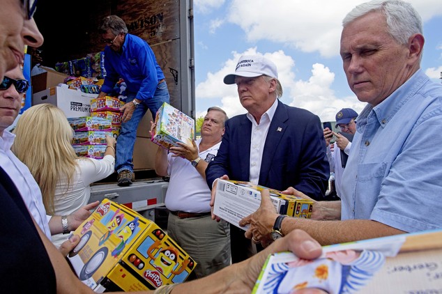 Republican presidential candidate Donald Trump and his running mate Indiana Gov. Mike Pence right help to unload supplies for flood victims during a tour