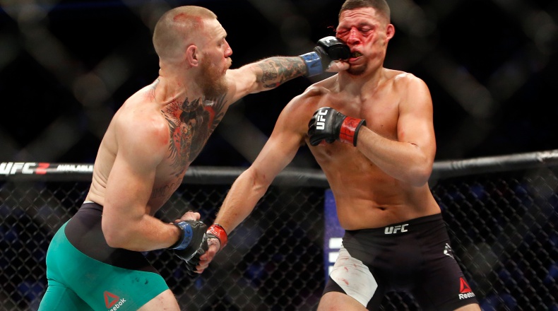 LAS VEGAS NV- AUGUST 20 Conor Mc Gregor hits Nate Diaz with a left during their welterweight rematch at the UFC 202 event at T Mobile Arena