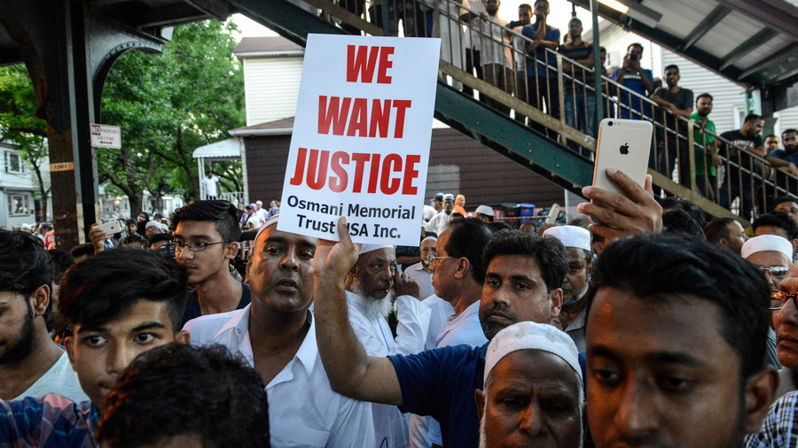 A crowd of community members gather at the place where Imam Maulama Akonjee was killed in the Queens borough of New York City