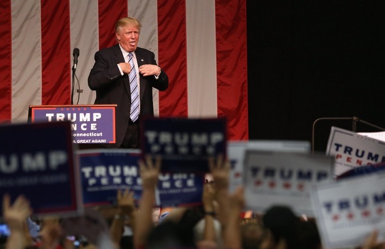 Republican Presidential candidate Donald Trump acknowledges the high temperature after addressing supporters