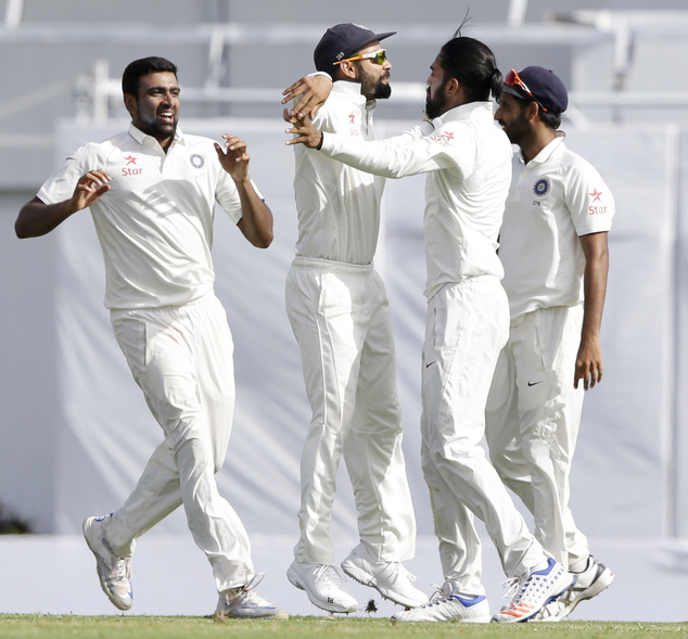 India's bowler Ravichandran Ashwin left and India's captain Virat Kohli celebrate with teammate Lokesh Rahul third from left after her run out West Indie