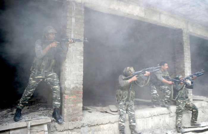 Indian army troops take position inside a building after a gunfight in Srinagar India on Monday. — AFP