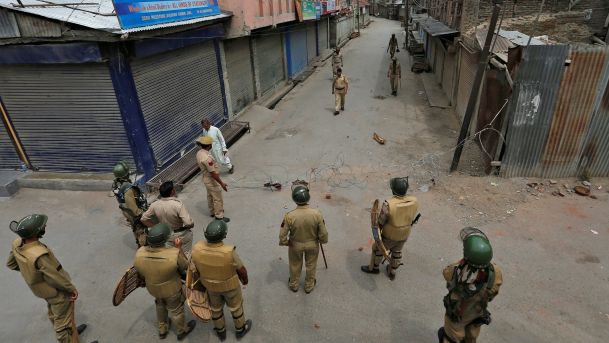 Indian police stand guard during a curfew in Srinagar