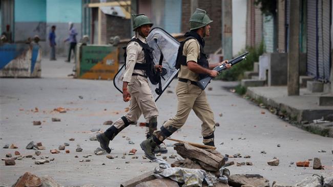 Indian policemen chase demonstrators during a protest in Srinagar Indian-controlled Kashmir