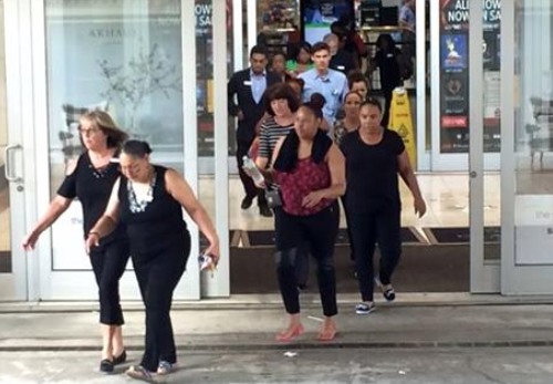 People rush from one of the exits of Crabtree Valley Mall in Raleigh N.C. Saturday Aug. 13 2016. Reports of gunshots inside the busy North Carolina mall caused chaos Saturday afternoon as shoppers ran screaming for the doors or sheltered in stores whil