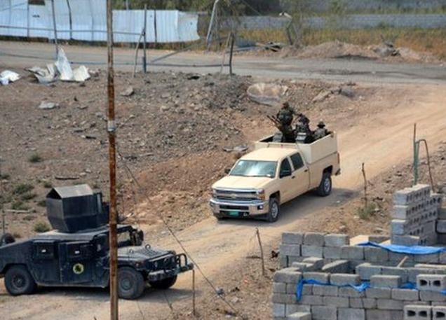 Members of the Iraqi government forces and the elite counter-terrorism service drive in Qayyarah after they took key positions in the centre of the city from the Islamic State