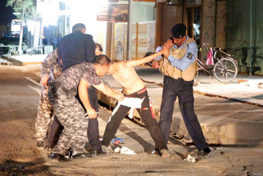 Iraqi security forces remove a suicide vest from a boy in Kirkuk on August 21