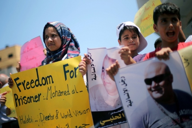 Palestinian demonstrators take part in a protest in solidarity with Mohammad El Halabi World Vision’s manager of operations in Gaza who was accused by Israel of funnelling millions of dollars in aid money to Hamas organised by foundations and societie