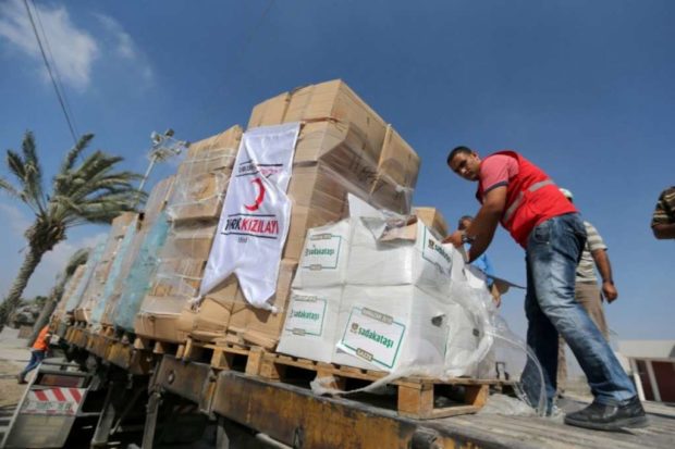 Palestinians check Turkish aid shipments upon arrival in the Gaza Strip at Kerem Shalom crossing between Israel and southern Gaza Strip