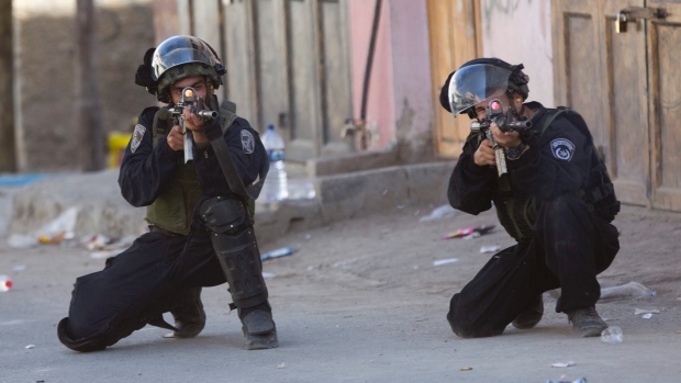 Israeli security forces aim their weapons during clashes in the West Bank refugee camp Fawwar near the West Bank city of Hebron on Tuesday