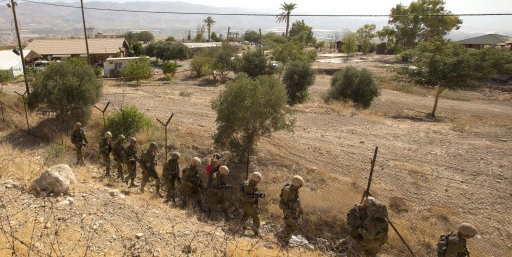 Israeli soldiers patrol a fence in the West Bank