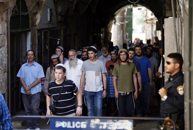 Israeli security forces stand guard as a group of Jewish men end their visit to the Temple Mount in Jerusalem during the annual Tisha B'Av fast day