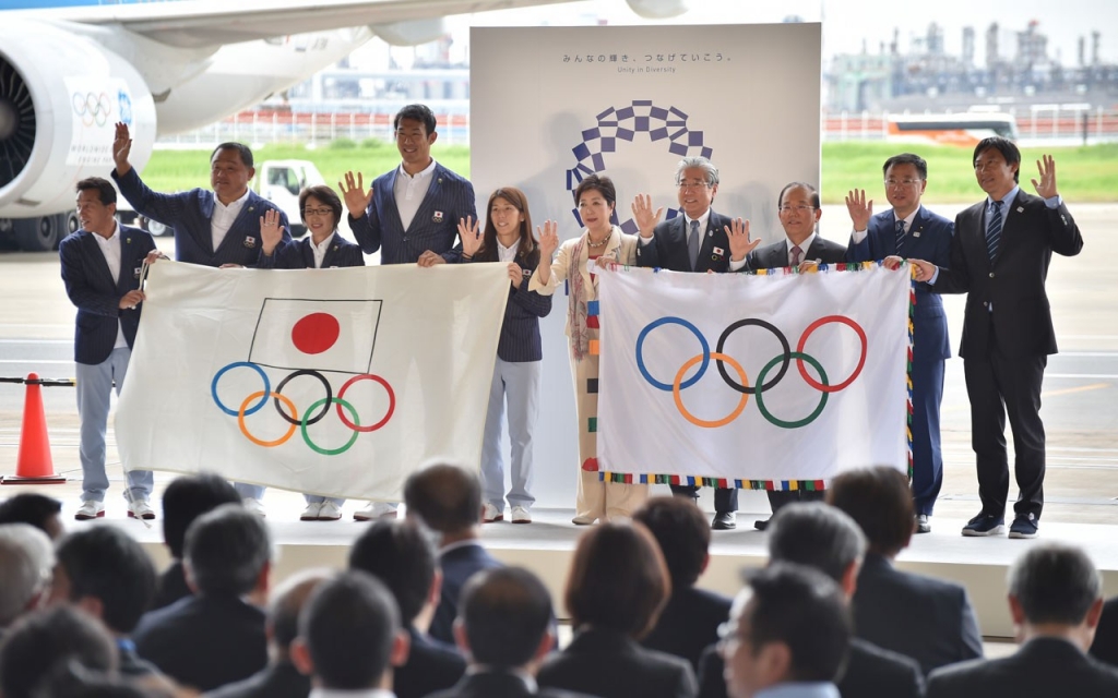 Tokyo governor Yuriko Koike, Japan Olympic Committee officials and their Rio de Janeiro Olympic squad leaders pose with flags during the offical flag arrival ceremony at the Tokyo's Haneda airport