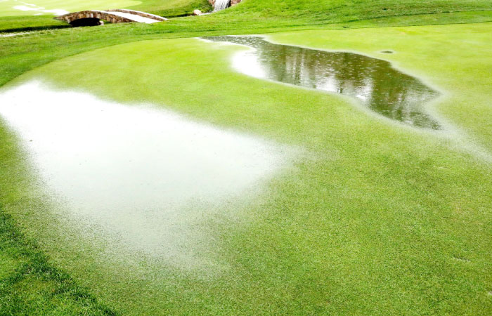 Puddles are seen on the 18th hole while play is suspended due to inclement weather during the third round of the 2016 PGA Championship at Baltusrol Golf Club in Springfield New Jersey. — AFP