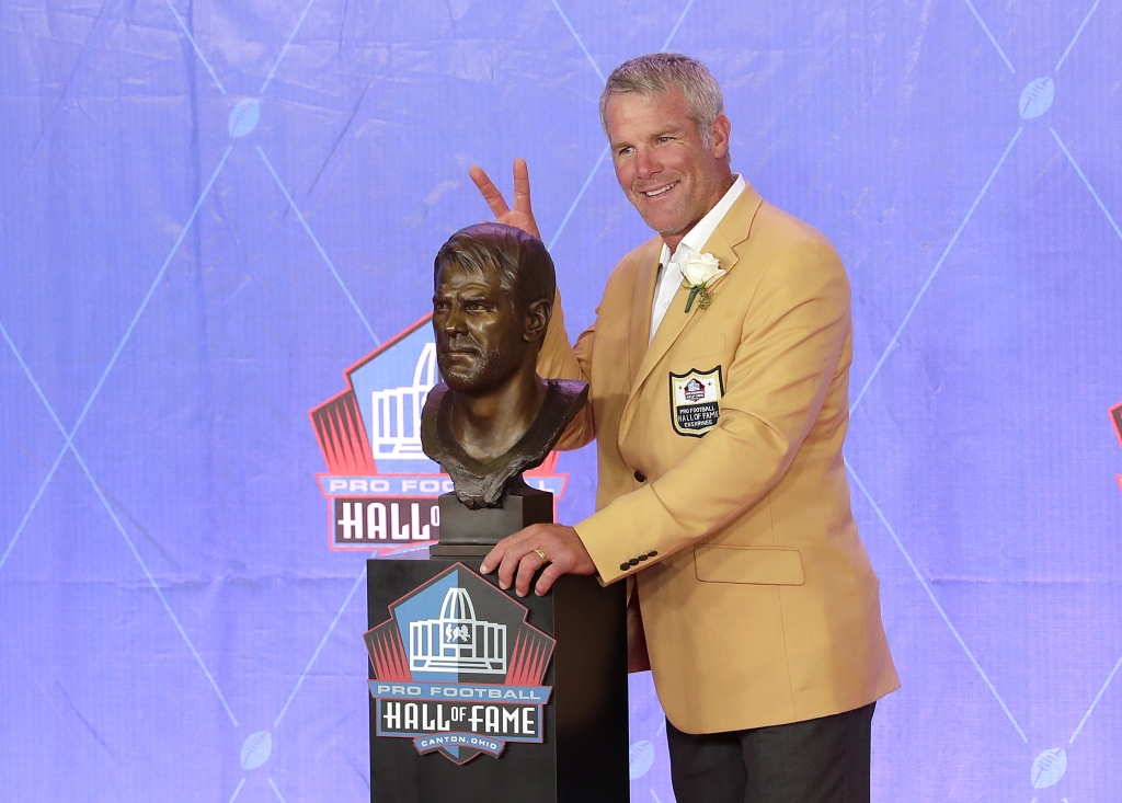 Brett Favre playfully jokes with his bust after his speech at the Pro Football Hall of Fame induction ceremony in Canton Ohio