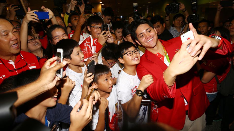 Joseph Schooling takes a selfie with fans at the Singapore Changi Airport on Aug. 15 2016