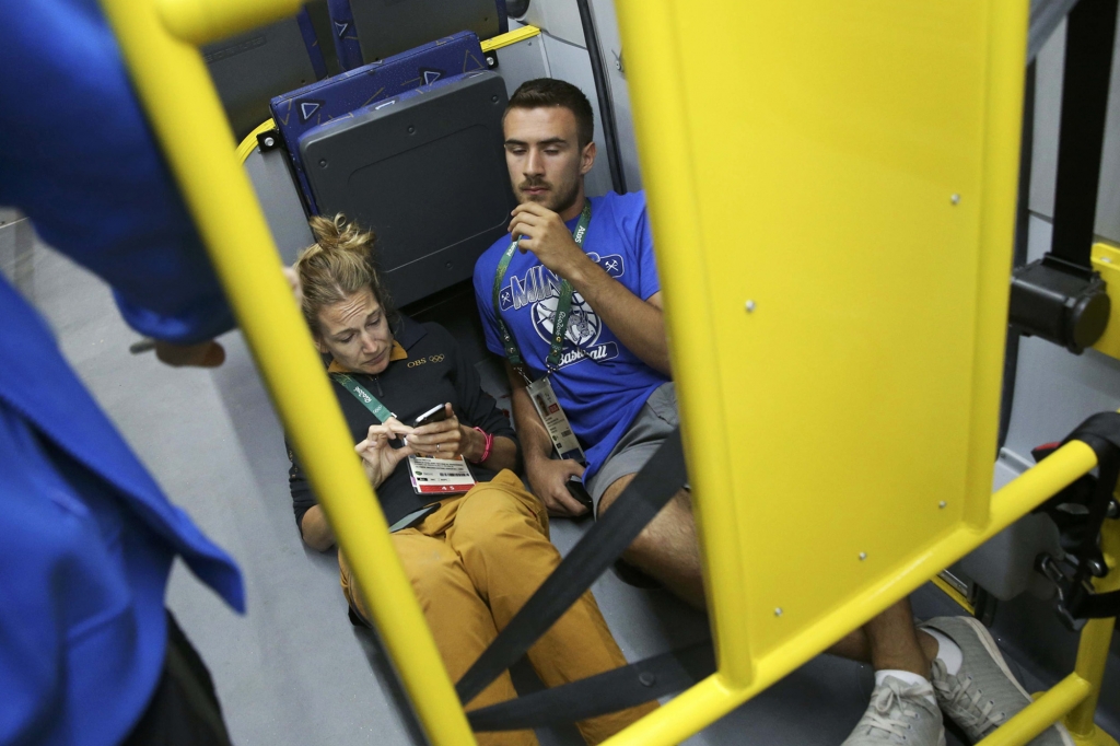 Journalists lie on the floor of the bus after a window was