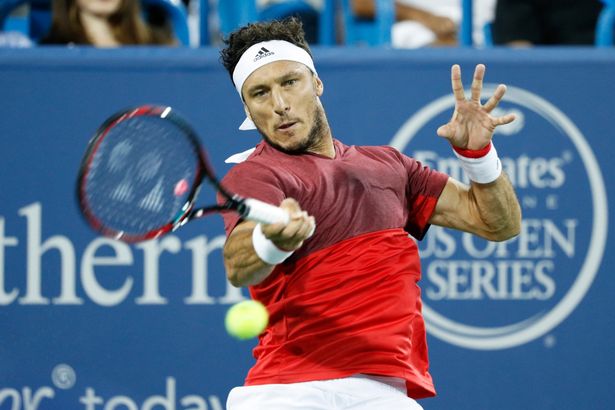 Juan Monaco of Argentina hits a return to Andy Murray of Great Britain on Day 5 of the Western & Southern Open at the Lindner Family Tennis Center