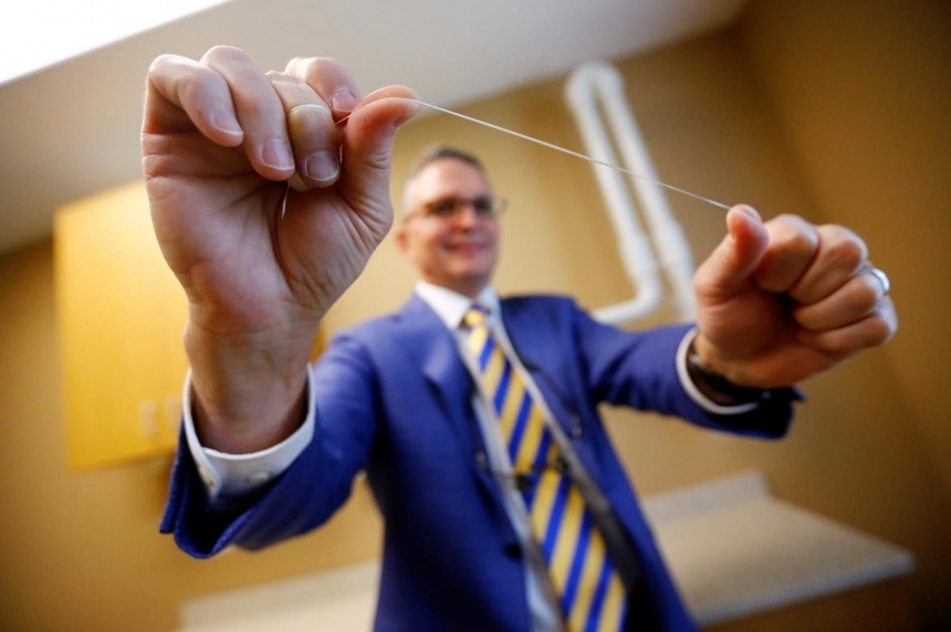 Wayne Aldredge president of the American Academy of Periodontology holds a piece of dental floss at his office in Holmdel N.J