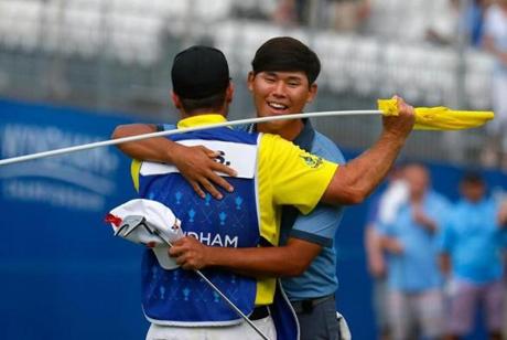 GREENSBORO NC- AUGUST 21 Si Woo Kim celebrates with his caddie after winning the Wyndham Championship during the final round at Sedgefield Country Club