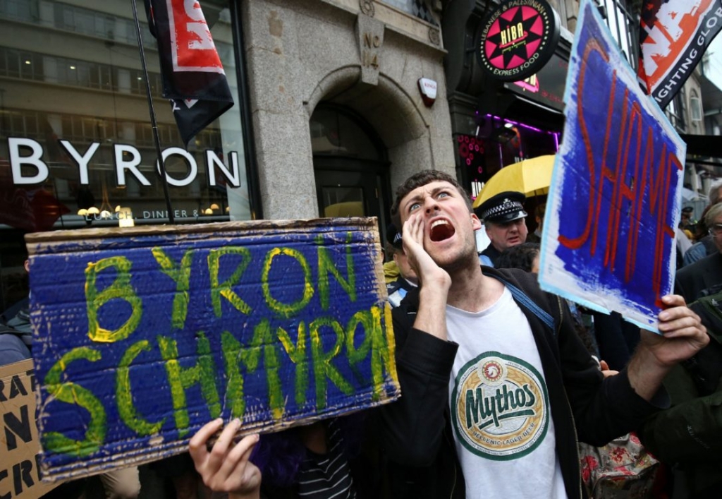 People unhappy with the way Byron dealt with its undocumented workers protest outside a store in Holborn London. The burger chain arrested 35 of its workers for being in the country illegally saying it didn't realize they were undocumented